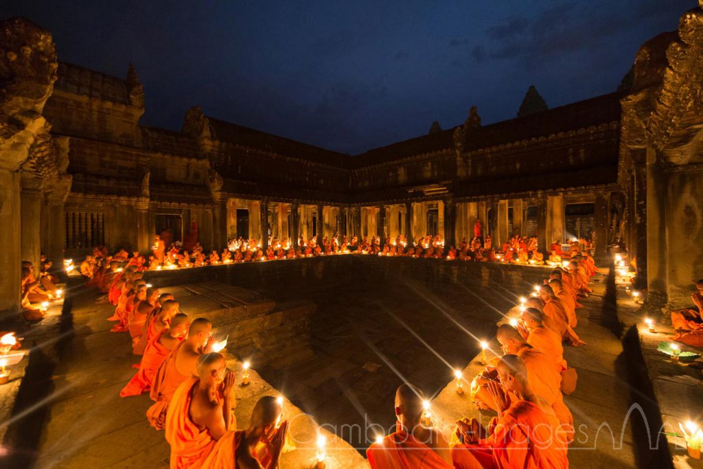 Monks meditate under candle light during a buddhist ceremony, Angkor Wat, Siem Reap, Cambodia.